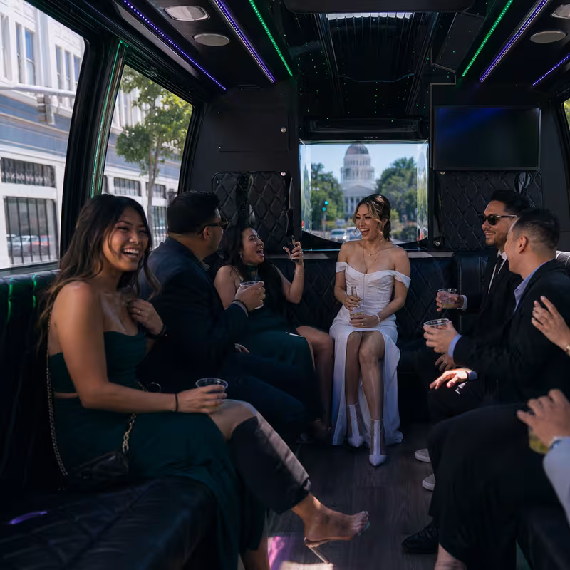 Party bus interior with wraparound leather seating and LED lighting in Sacramento